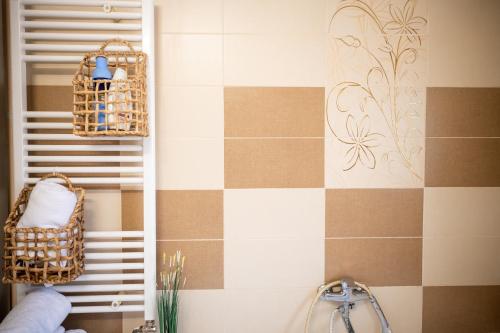 a bathroom with brown and white tiled walls and baskets at Aly&Emy 2 in Caransebeş