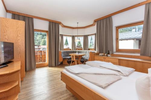 a hotel room with a bed and a television at Apart-Hotel Forellenhof in Saalbach Hinterglemm