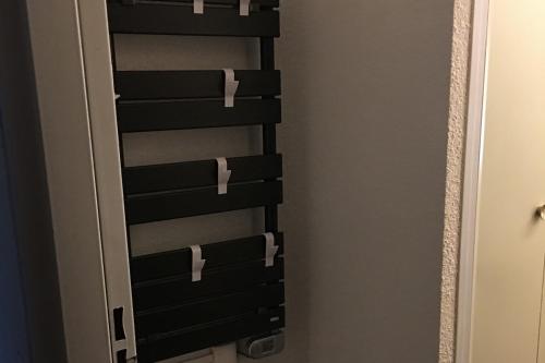 a closet with a black rack with white handles at Studio cabine 5 couchages - Station du Collet d'Allevard in Allevard