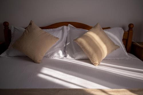 a bed with four pillows on top of it at Aly&Emy 2 in Caransebeş