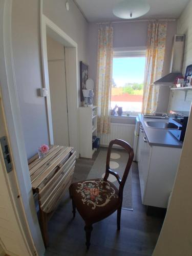 a kitchen with a bench and a sink and a window at Båstad Stationsterrassen 9 in Båstad