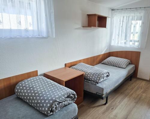 a room with two beds and a table and a window at Szumi domek in Kołobrzeg