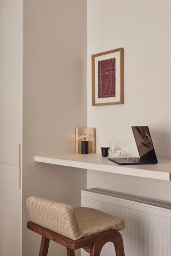 a room with a chair and a laptop on a shelf at Ikima Living in Piraeus
