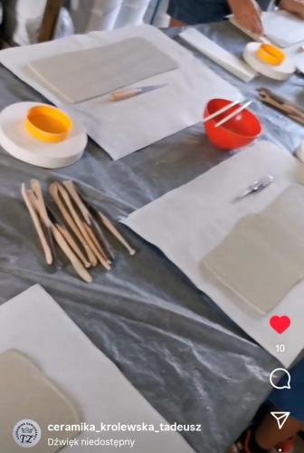 a table with plates and utensils on top of it at Nocleg u garncarza in Kamienica Królewska