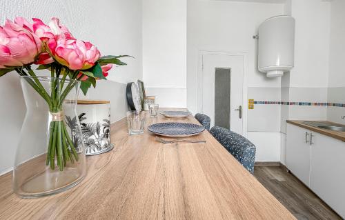 une table avec des roses roses dans un vase dessus dans l'établissement Séjour calme au cœur de Brest, vue sur la rade, à Brest