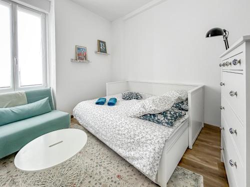 une petite chambre avec un lit et un canapé dans l'établissement Séjour calme au cœur de Brest, vue sur la rade, à Brest