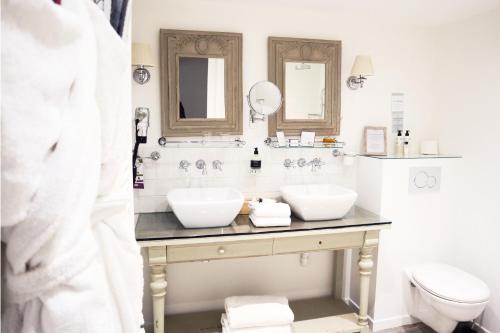 a bathroom with two sinks and a toilet at Le Domaine Du Colombier in Malataverne
