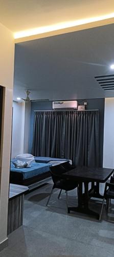a room with a bed and a table and a window at Dharwad Residency in Dhārwād