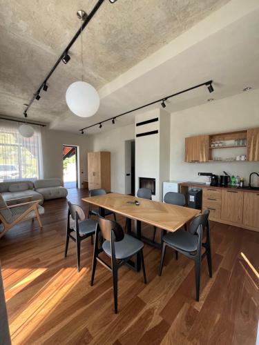 a kitchen and living room with a wooden table and chairs at Котеджі Грань in Bukovel
