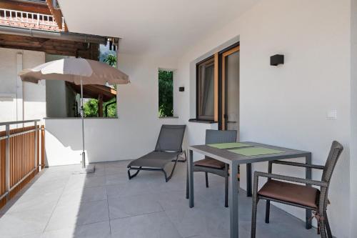 a patio with a table and chairs and an umbrella at Unterdornerhof Algund in Lagundo