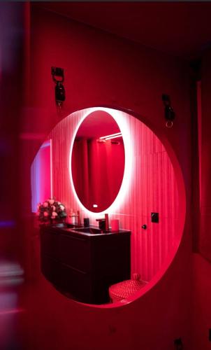 a red bathroom with a mirror and a sink at Nos Limites Room in Ollioules