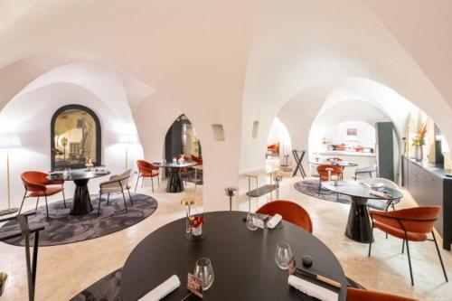 a dining room with tables and chairs in a building at Le Domaine Du Colombier in Malataverne