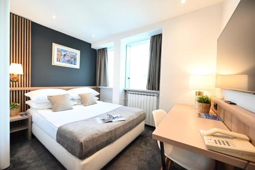 a hotel room with a bed and a desk at Hotel Central in Zagreb