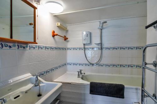 a bathroom with a tub and a sink at Finest Retreats - April Cottage in Cawsand