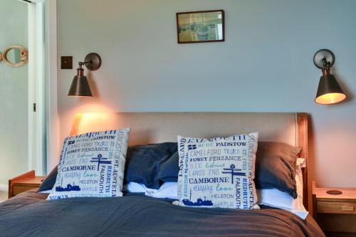 a bedroom with a bed with two pillows on it at Finest Retreats - April Cottage in Cawsand