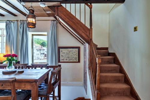 a dining room with a table and a staircase at Finest Retreats - April Cottage in Cawsand