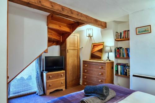 a bedroom with a loft bed with a tv and a dresser at Finest Retreats - April Cottage in Cawsand