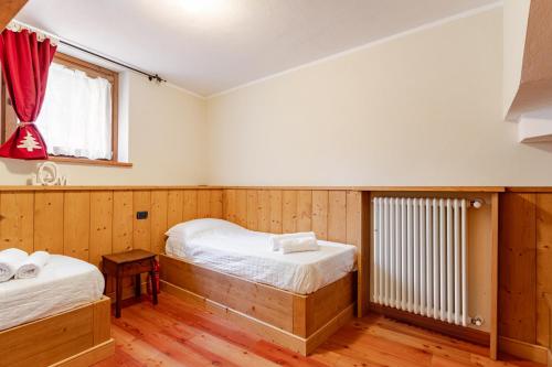 a bedroom with two beds and a window at Chalet Après-ski Courmayeur center in Courmayeur