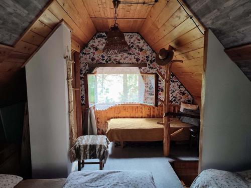 Habitación pequeña en el ático con cama y ventana en Chata na vrcholu Boreckých skal, en Hnanice