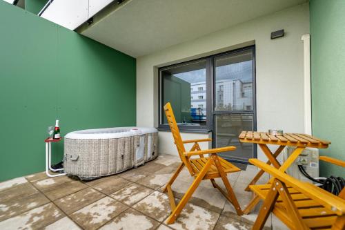 a room with a tub and a chair and a table at AH Radnica Spa Jacuzzi in Košice