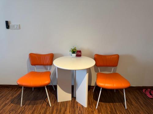a table and two orange chairs in a waiting room at K Avenue High Floor Studio Balcony with Sunrise View in Kota Kinabalu