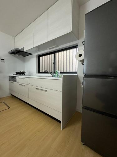 a kitchen with white cabinets and a stainless steel refrigerator at Near the station, no fee parking, 1 limited group, quiet residence, 2 floors 3LDK, 18 minutes from Nippori, Akihabara, Ueno, Tokyo 30 minutes in Tokyo