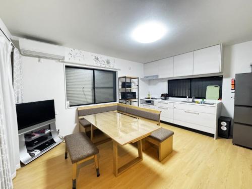 a kitchen with a dining table and a kitchen with white cabinets at Near the station, no fee parking, 1 limited group, quiet residence, 2 floors 3LDK, 18 minutes from Nippori, Akihabara, Ueno, Tokyo 30 minutes in Tokyo