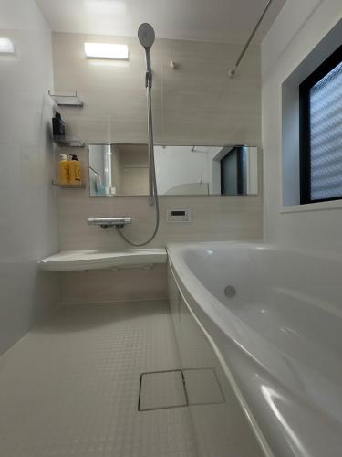 a white bathroom with a bath tub and a mirror at Near the station, no fee parking, 1 limited group, quiet residence, 2 floors 3LDK, 18 minutes from Nippori, Akihabara, Ueno, Tokyo 30 minutes in Tokyo