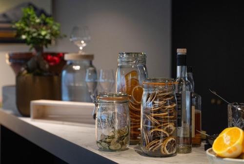 a counter with glass jars and bottles on a table at Le Domaine Du Colombier in Malataverne