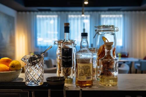 a table with bottles of alcohol and a bowl of oranges at Le Domaine Du Colombier in Malataverne