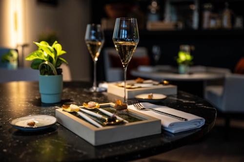 a table with two glasses of wine and a plate of food at Le Domaine Du Colombier in Malataverne