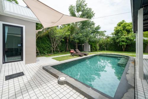 a swimming pool in the backyard of a house at BRAND-NEW! The Private PoolVilla /4BR byน้องมังคุด in Nong Prue