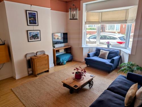 een woonkamer met een blauwe bank en een tafel bij Salty Escape in Saltburn-by-the-Sea