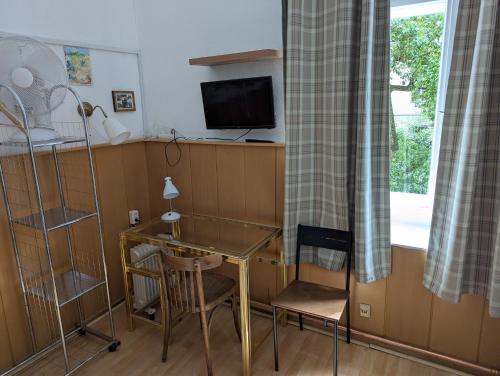 a room with a desk and a table and a window at Hotel Pension Waizenegger am Kurfürstendamm in Berlin