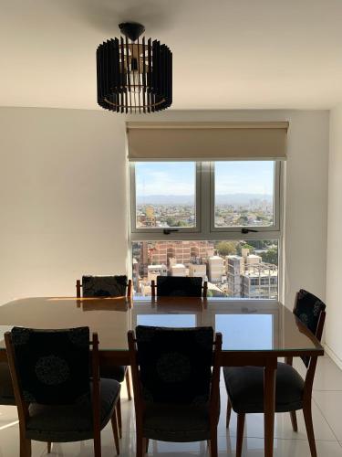 a dining room with a table and chairs and a window at ALOHA Güemes Premium, 2 dorm con Vista a las Sierras in Córdoba