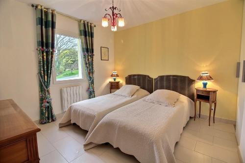 a bedroom with two beds and a window at Les jardins de kerarzic in Ploubazlanec