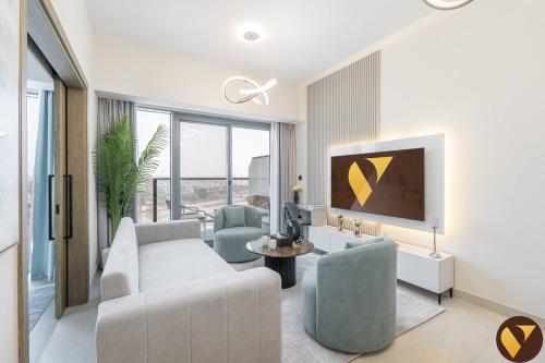 a living room with a couch and a tv at Vogue Vacation Homes, Damac Hills Golf Gate near First Avenue Mall, Two Bedroom Apartment with Balcony and Vibrant Community View, Access to all Amenities in Dubai