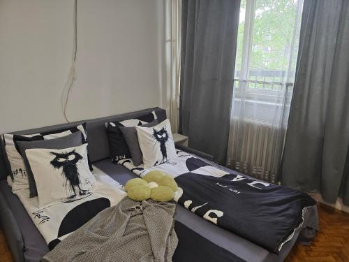 a bed with a teddy bear sitting on top of it at Aparmani Djuric in Subotica