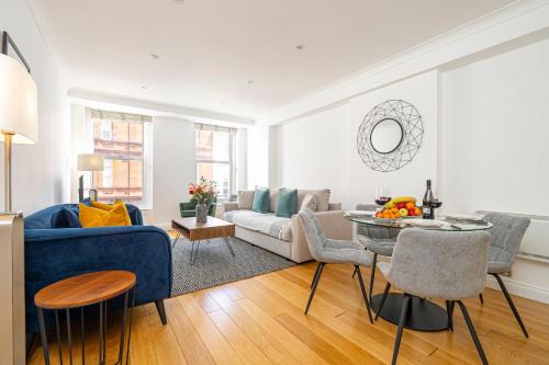 a living room with a blue couch and a table at Covent Garden Residence in London