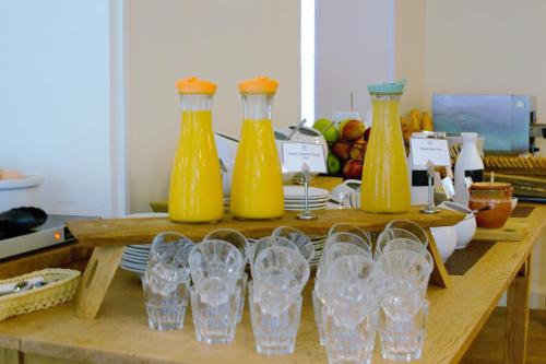a table with four yellow bottles and glasses on it at The Royal Foundation of St Katharine in London