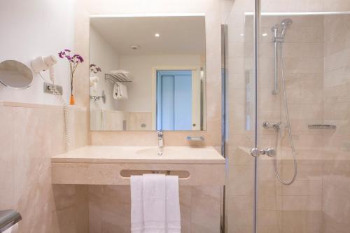 a bathroom with a sink and a shower at Hipotels Barrosa Garden in Chiclana de la Frontera