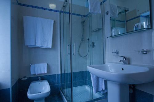 La salle de bains est pourvue d'un lavabo, d'une douche et de toilettes. dans l'établissement Hotel Adriano, à Turin