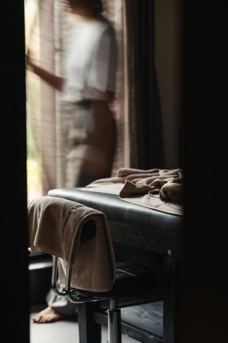 a bed in a room with a person looking out the window at Silverback Lodge in Buhoma