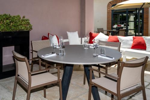 a round table with chairs and wine glasses on it at Le Domaine Du Colombier in Malataverne