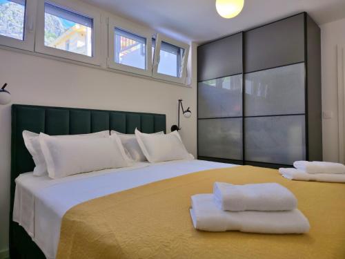a bedroom with a large bed with two towels on it at Apartment MM in Omiš