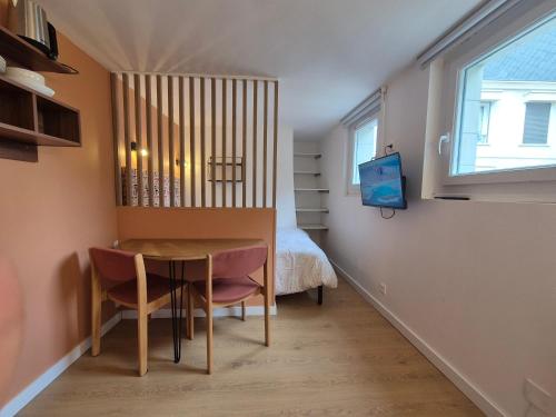 Cette petite chambre comprend une table et un lit. dans l'établissement Studio Rouen Hypercentre 2 personnes Le Terracotta, à Rouen