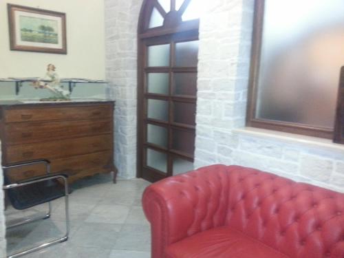 a living room with a red couch and a dresser at Appartamento Centrale in Molfetta