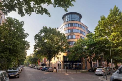 a tall building on a city street with cars parked at Scandic Berlin Kurfürstendamm in Berlin