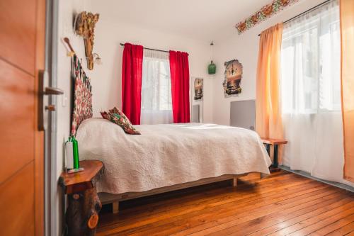 a bedroom with a bed with red curtains at AYCA La Flora Hotel Boutique in Valparaíso