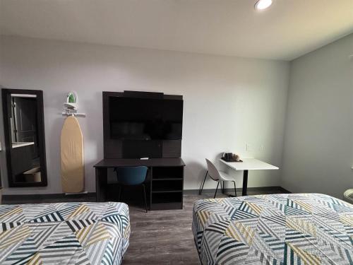 a bedroom with a bed and a tv and a desk at Studio 6 Giddings in Giddings